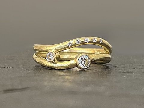 Svungen guldring med dimanter