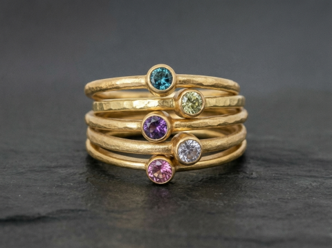 Stack guld ringe med farvede sten