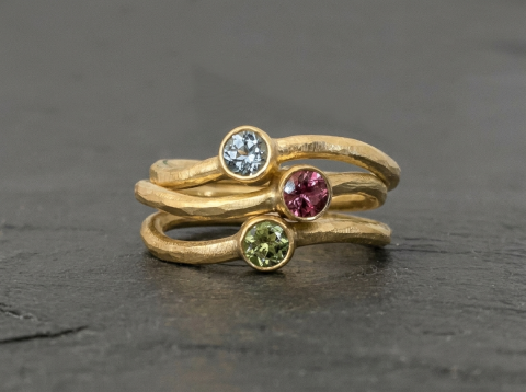Stack ringe i guld med farvede sten